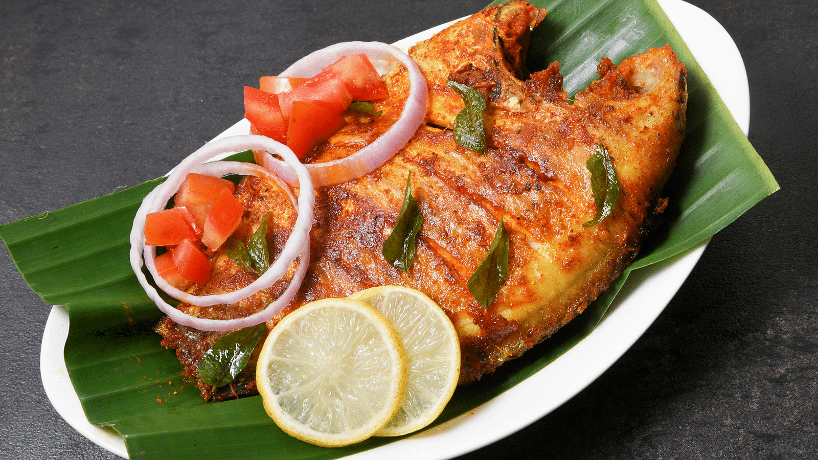 a view from above of Fried fish on a leaf - Rhythm Kumarakom