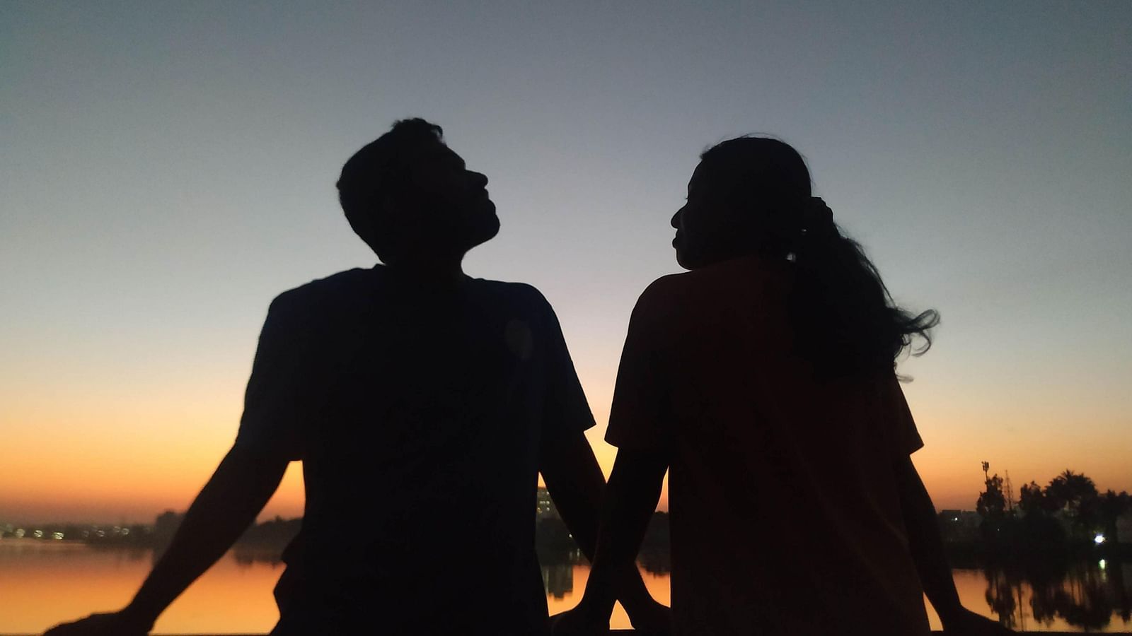 couple silhouette while sitting in front of a waterbody - Rhythm Kumarakom
