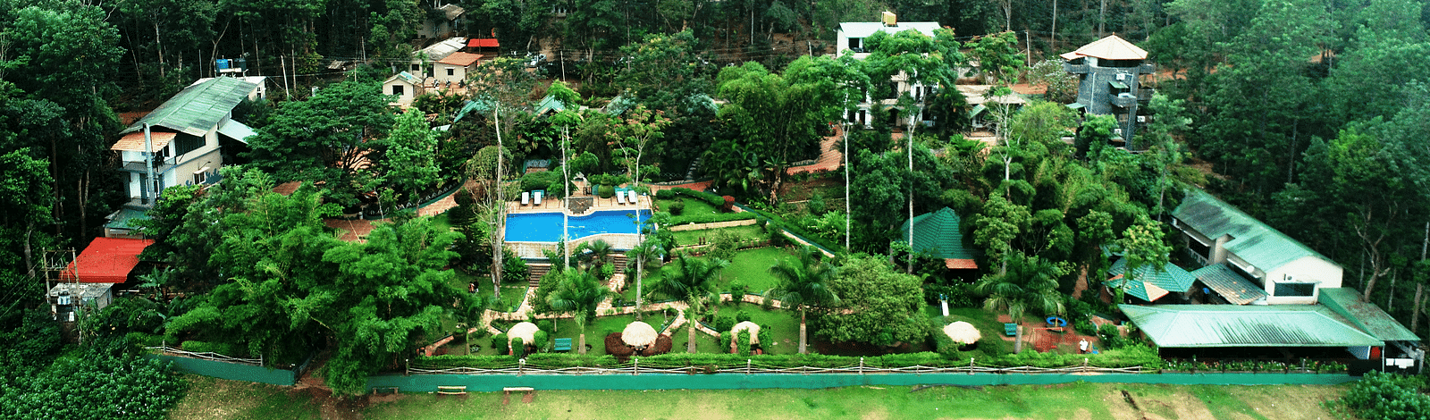Aerial view of Coorg Jungle Camp Backwater Resort, Kushalnagar surround by lush greenery.