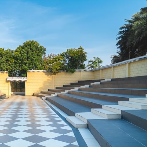 An image of an outdoor amphitheatre showcasing an open stage, coridor, and stairs where spectators sit - The Garden Ananta Elite, Rajkot