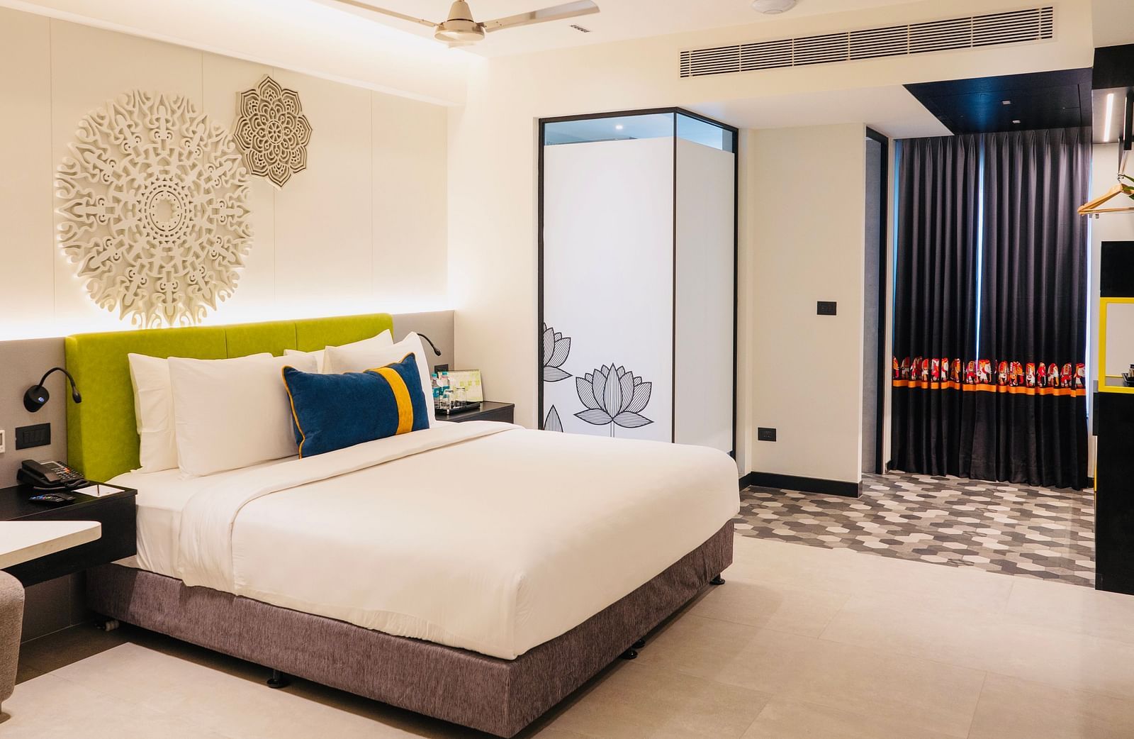 An image of a bedroom showcasing a sculptured headboard at Zibe Luxe Kakinada by GRT Hotels