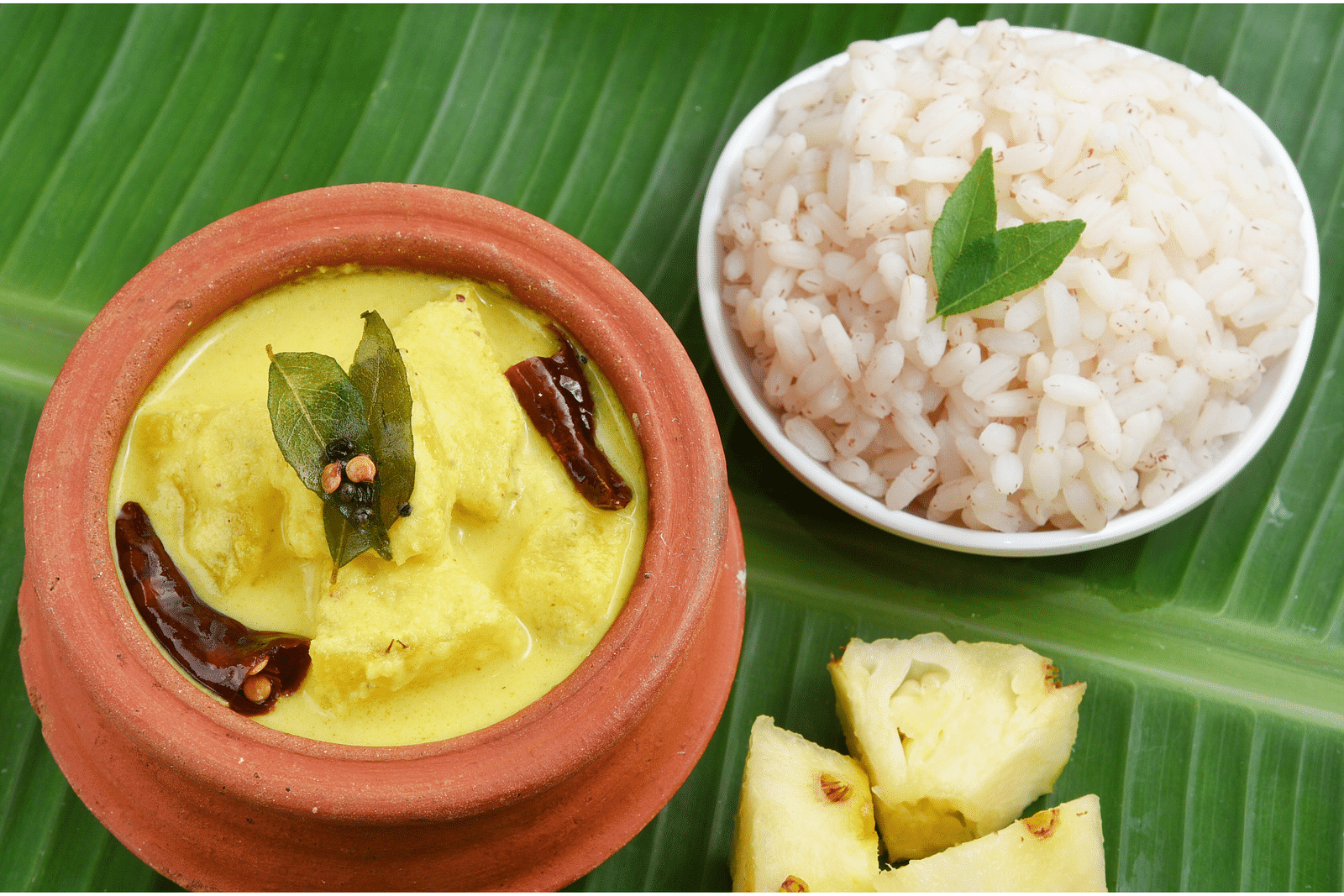 a view from above of White rice and curry on banana leaf - Rhythm Kumarakom