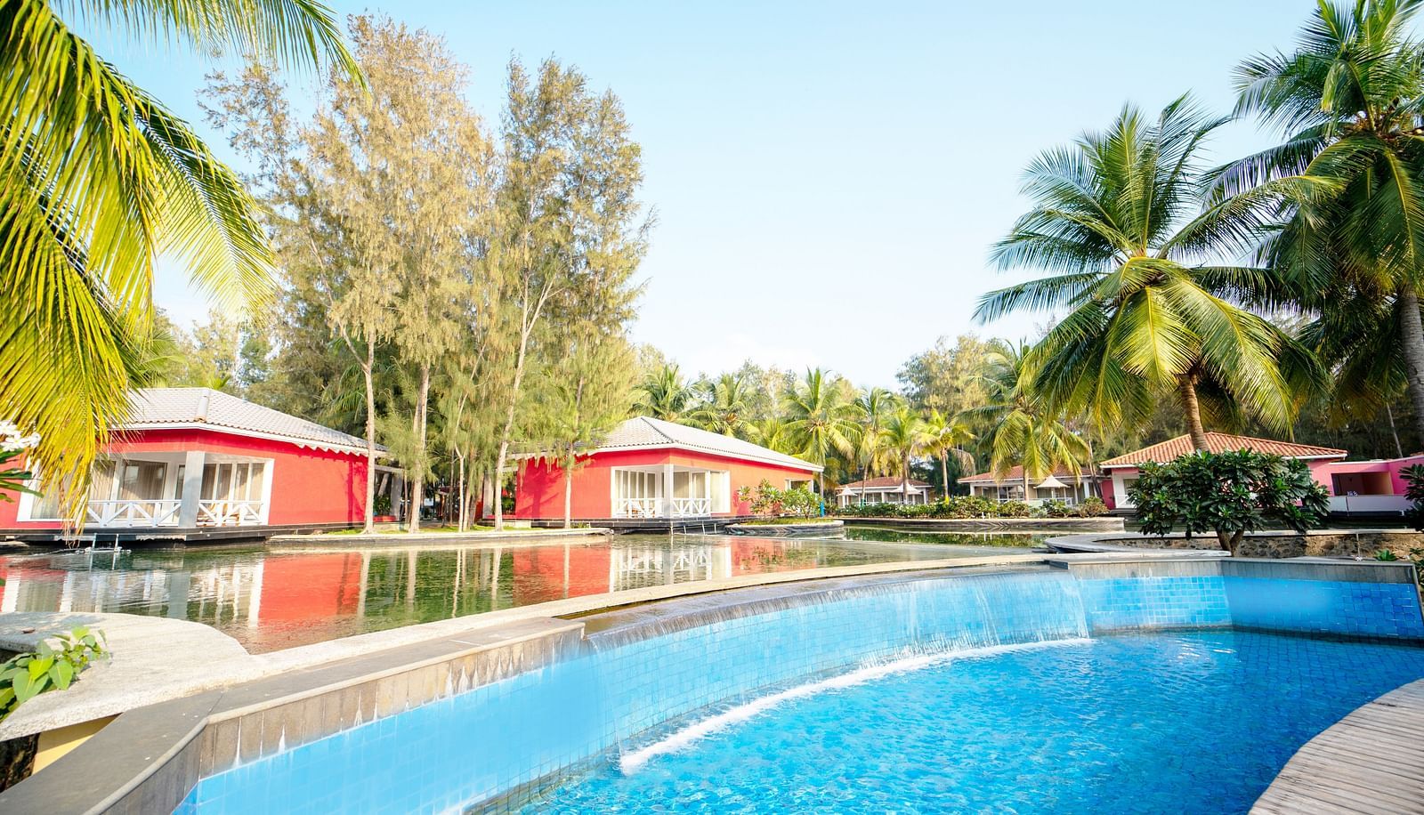 Swimming Pool with two red houses on the side with trees on the side - Ocean Spray, Puducherry
