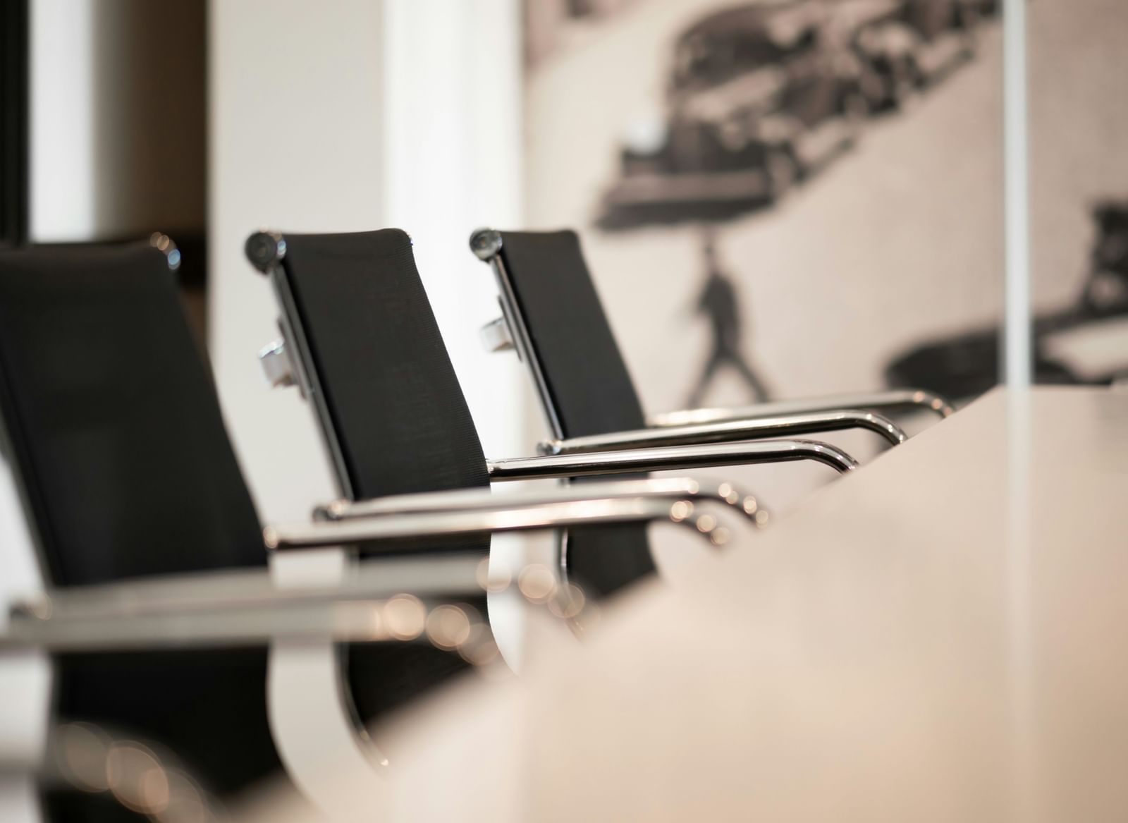 A close-up shot of a modern conference room featuring office chairs aligned beside a meeting table.
