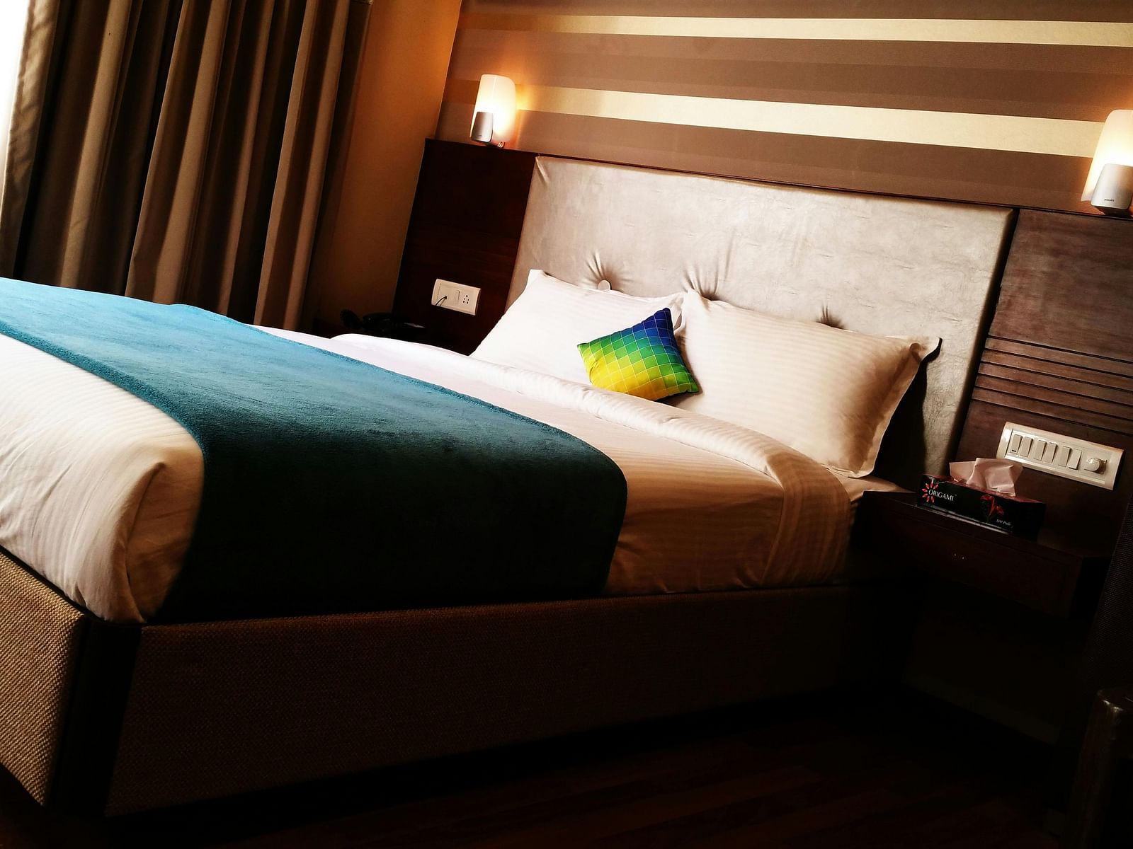 a bedroom with a large bed and two mounted side lamps