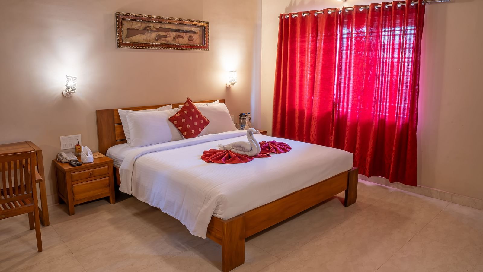 Attic Villa setting features a bed with white linens, red curtains, and basic furniture | Woodstock Resorts, Coorg