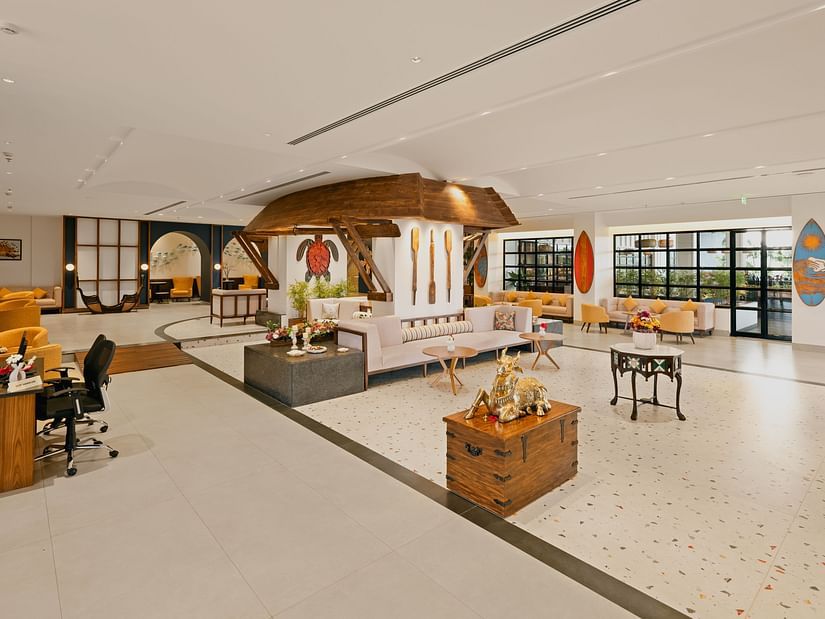 Lobby space featuring sofas and chairs, with a wall hanging turtle craft and decorative paddles at Cloud9 Sarovar Premiere, Palolem Goa.