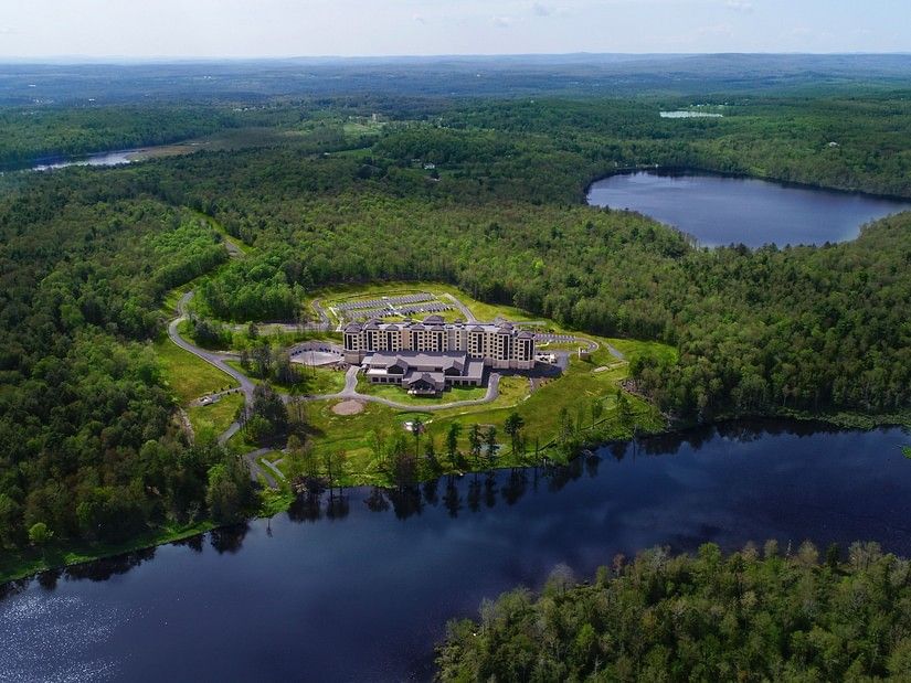 Exterior view of YO1, Catskills, New York, showcasing its modern architecture surrounded by lush greenery.