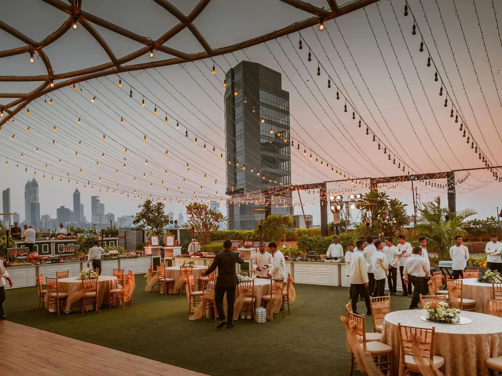 A large, open event space with a high arched ceiling, with round tables and chairs set up for a reception.