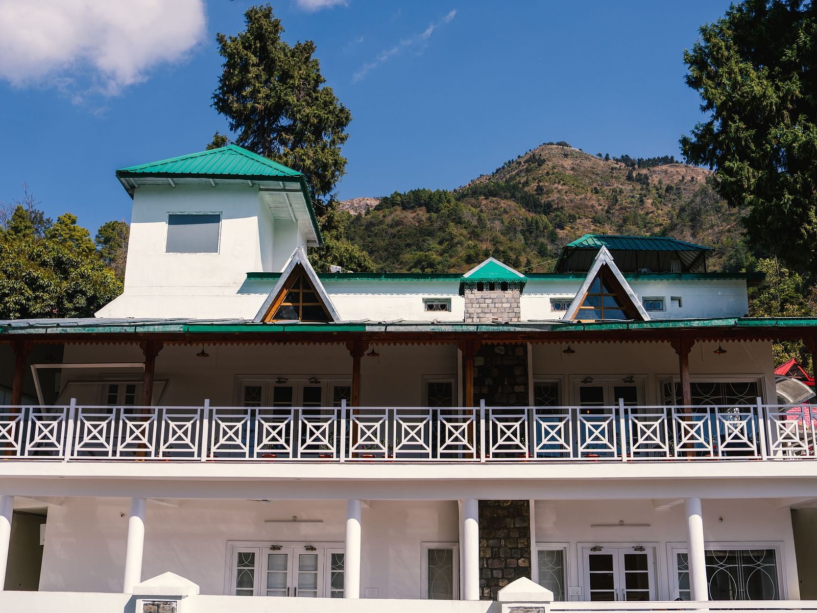 Facade of BluSalzz Villas - The Green Roof, Bhimtal, is set against a stunning backdrop of mountains and lush trees.