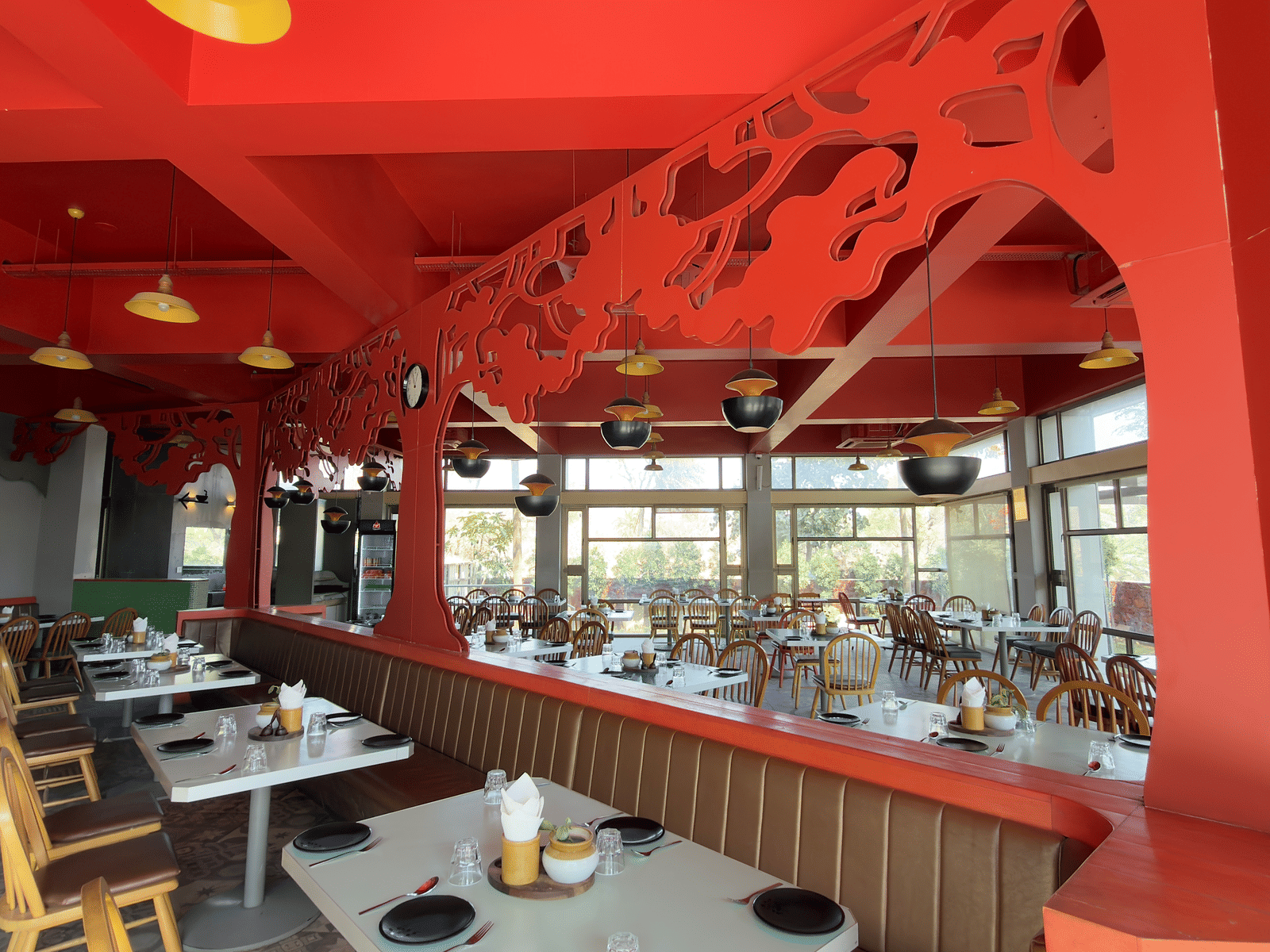 The restaurant at Vinti Resort, Ambaji, featuring a striking ceiling and comfortable tables set for dining