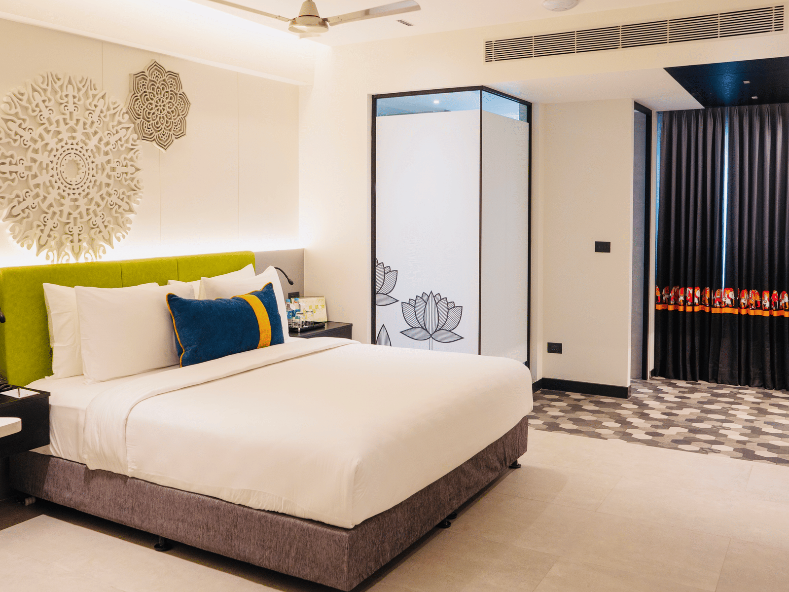 A bedroom showcasing a sculptured headboard at Zibe Luxe Kakinada by GRT Hotels that provide luxury rooms in Kakinada.