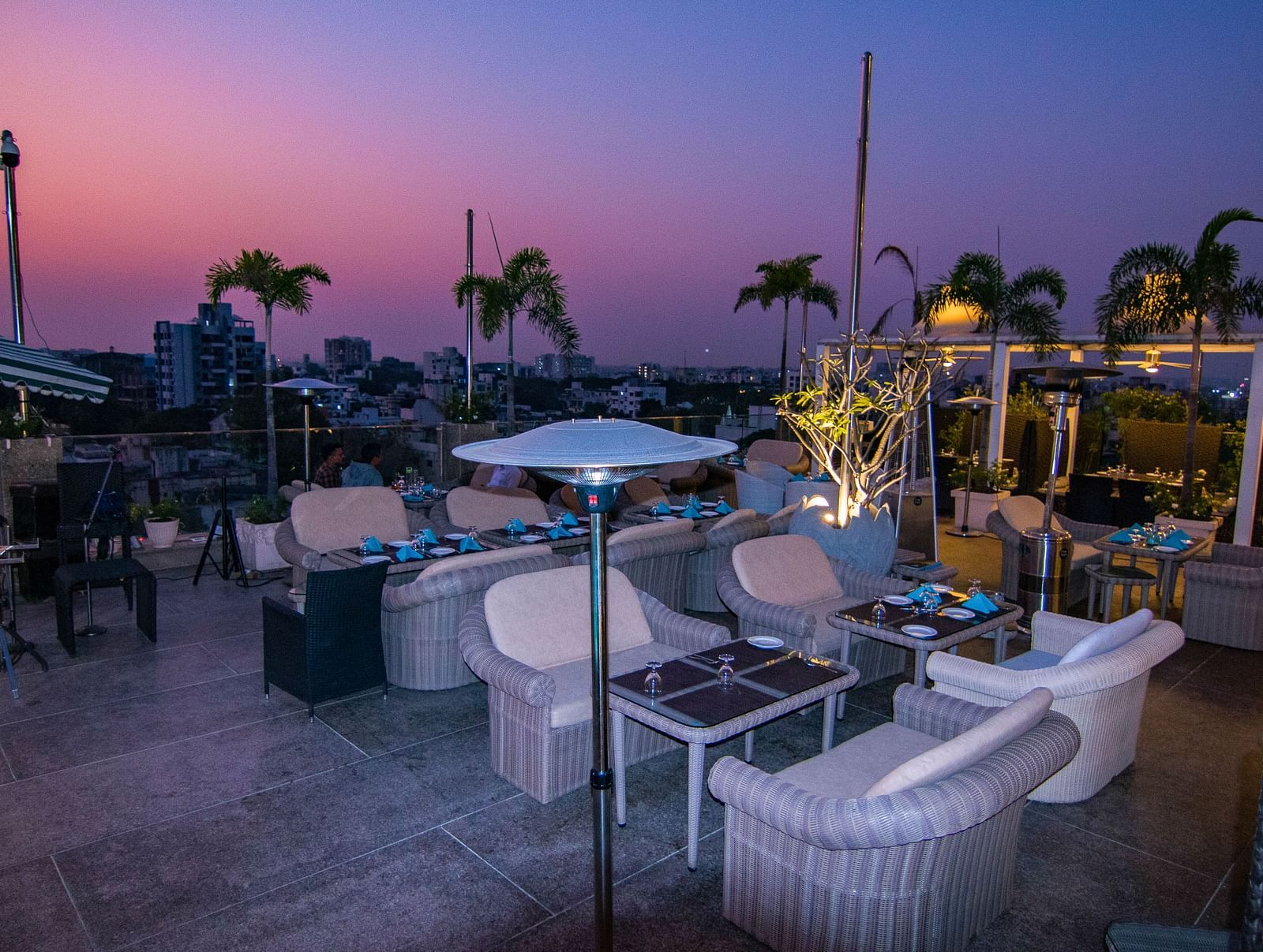 An outdoor dining setup at dusk at Hotel Ashok Nagpur.