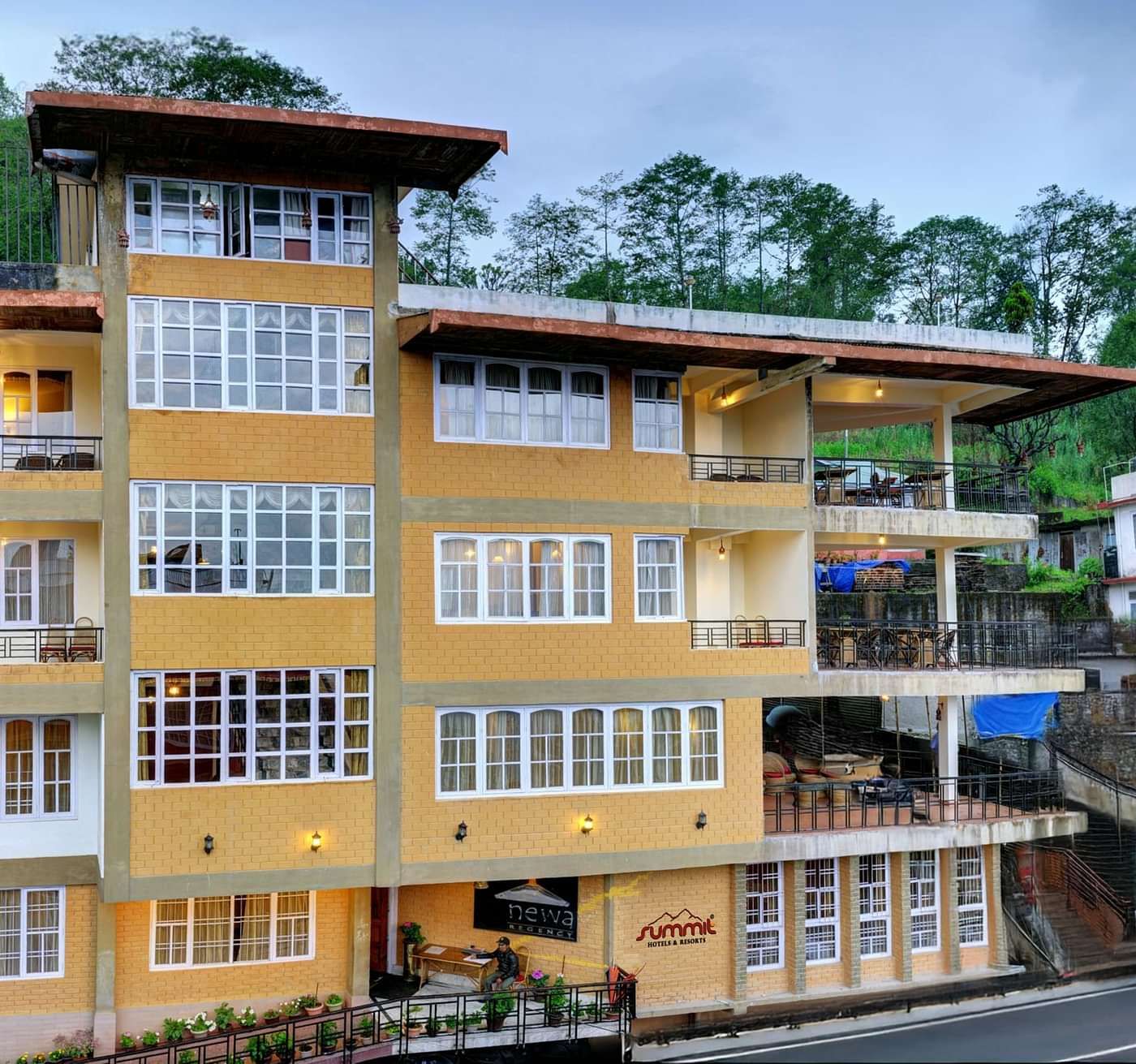 Facade view of Summit Newa Regency & Spa, Pelling, surrounded by tall green trees