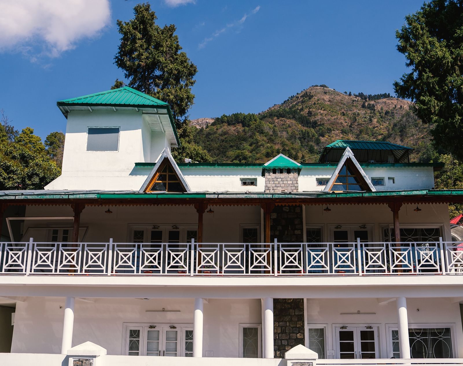 Facade of BluSalzz Villas - The Green Roof, Bhimtal, is set against a stunning backdrop of mountains and lush trees.