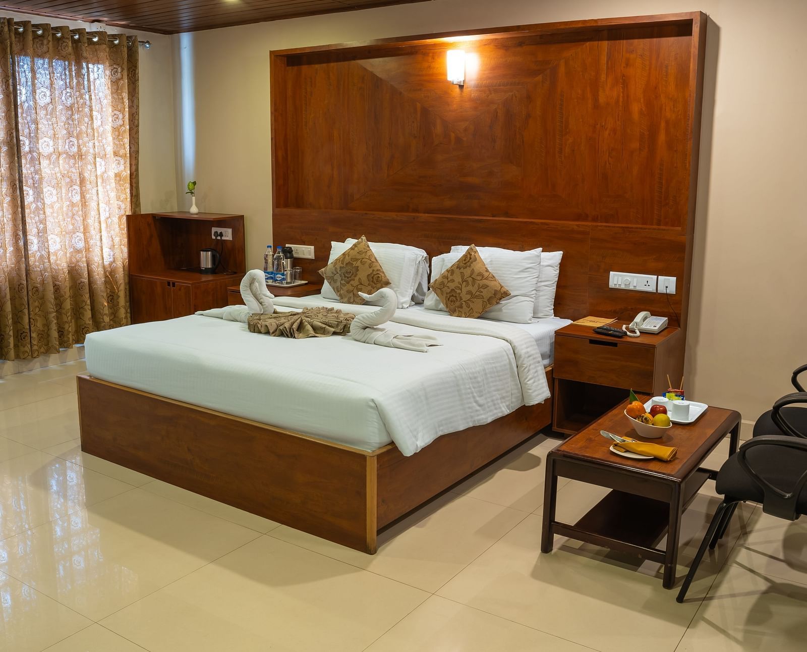 Superior Room includes a king size bed, a wooden headboard, and a sitting area | Woodstock Resorts, Coorg