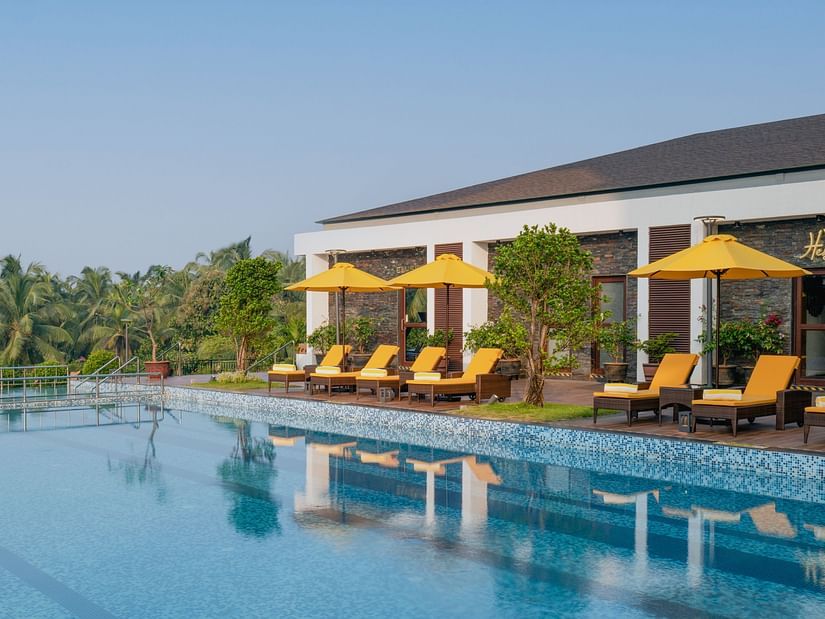 an image of a swimming pool with sun loungers at Cloud9 Sarovar Premiere, Palolem Goa
