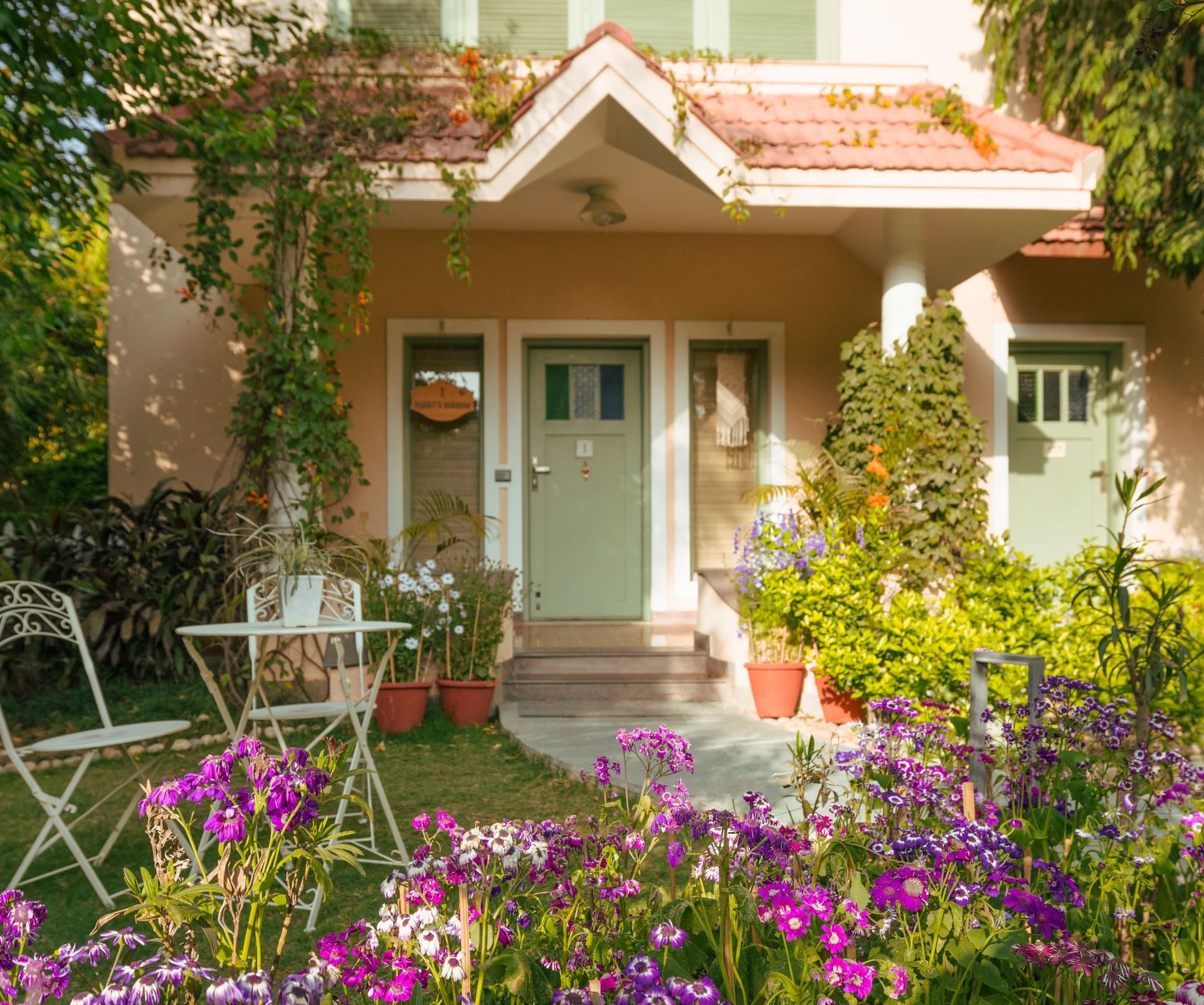 Charming garden seating area surrounded by flowers and greenery at Karma Chalets.
