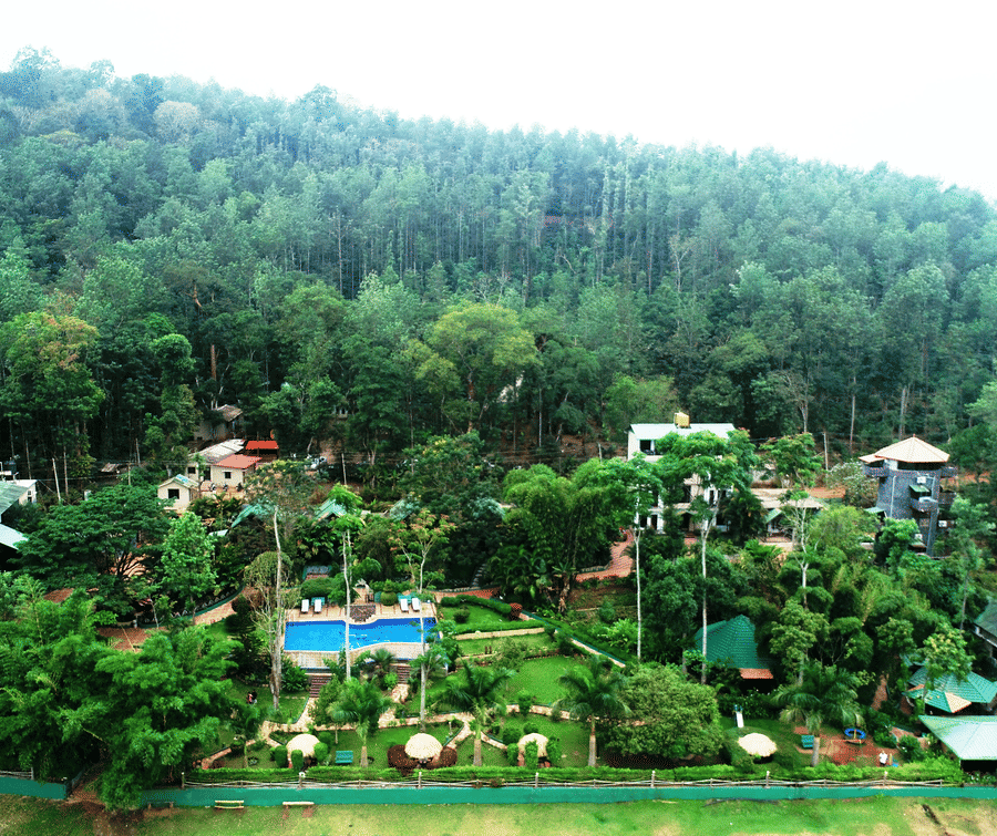 Aerial view of Coorg Jungle Camp Backwater Resort, Kushalnagar surround by lush greenery.