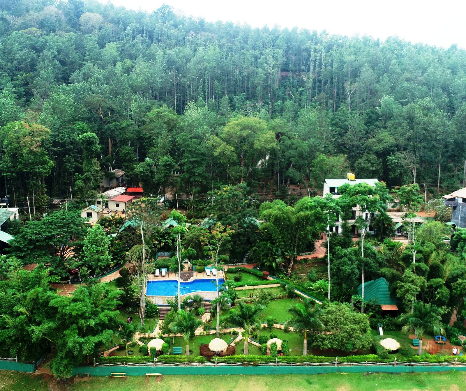 Aerial view of Coorg Jungle Camp Backwater Resort, Kushalnagar surround by lush greenery.