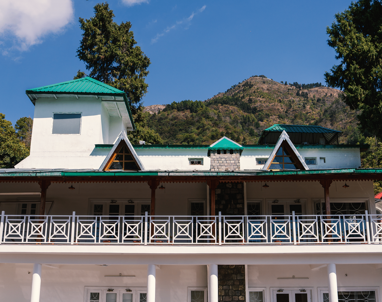 Facade of BluSalzz Villas - The Green Roof, Bhimtal, is set against a stunning backdrop of mountains and lush trees.