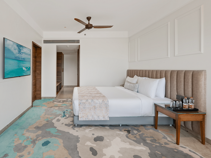 an image of side view of a bedroom with water bottles and glasses placed next to the bed at Cloud9 Sarovar Premiere, Palolem Goa.