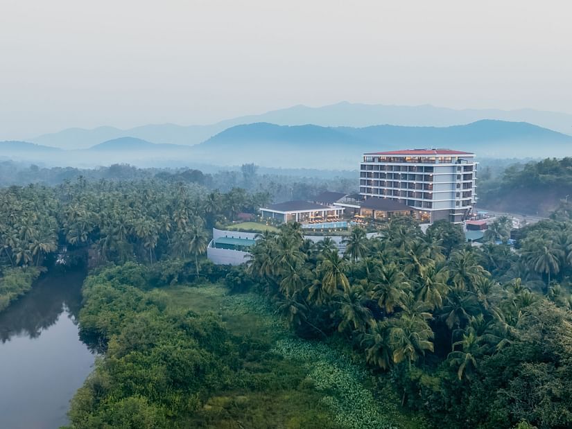 an image of aerial view of Cloud9 Sarovar Premiere, Palolem Goa surrounded by trees and mountains and water body