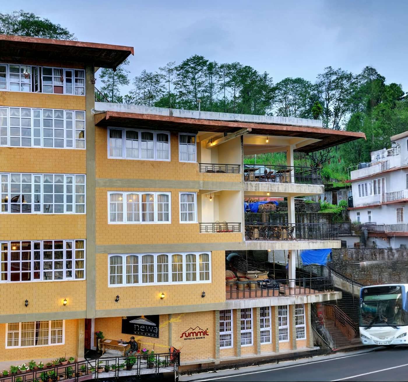 Facade view of Summit Newa Regency & Spa, Pelling, surrounded by tall green trees