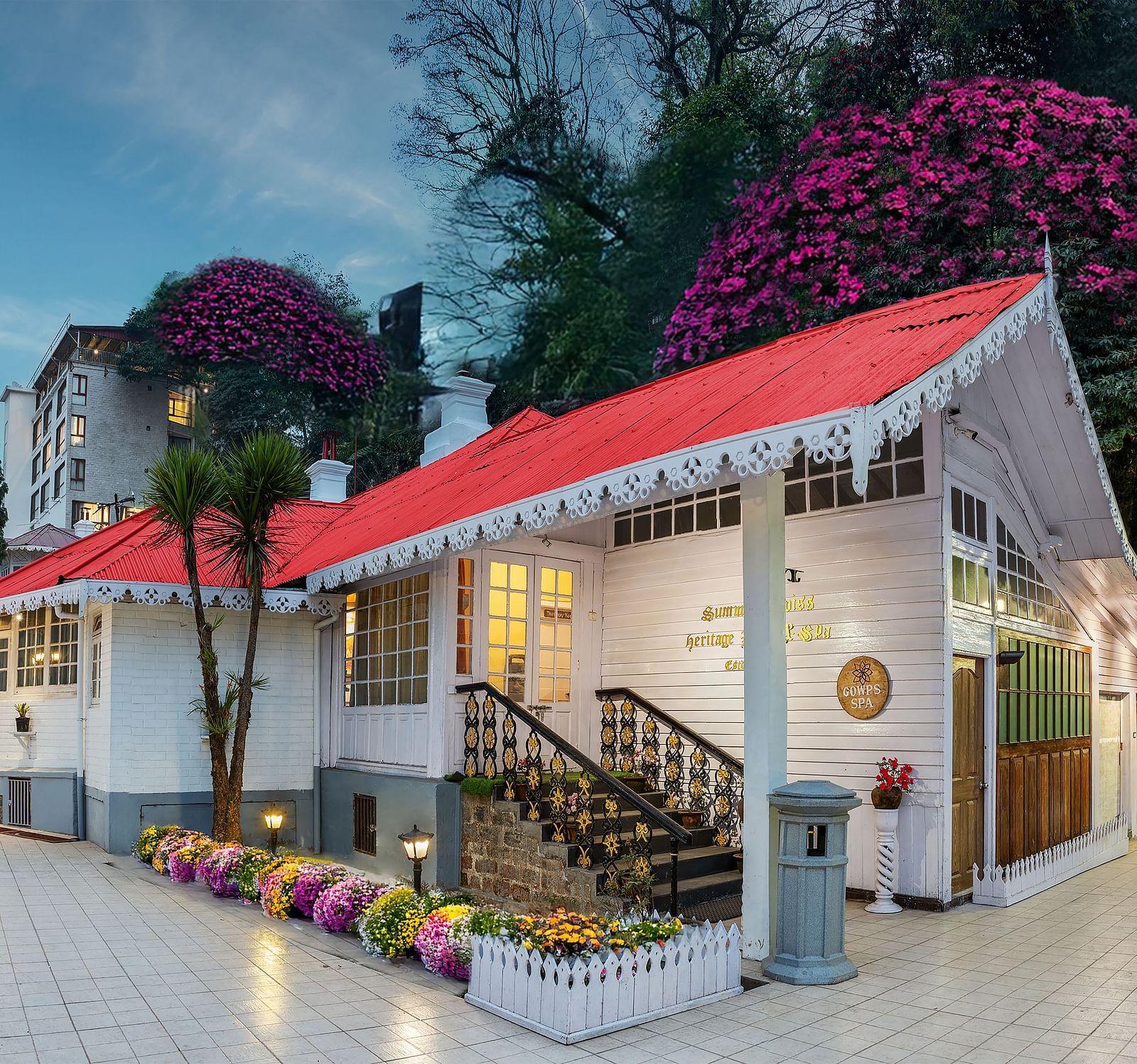 Facade view of Summit Swiss Heritage Resort & Spa, Mall Road, featuring the entrance, outdoor seating, and lush trees surrounding the property