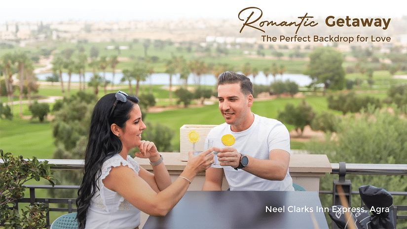 Banner for Romantic Getaway for Neel Clarks Inn Express featuring a couple clinking their beverage glasses at the table in the balcony