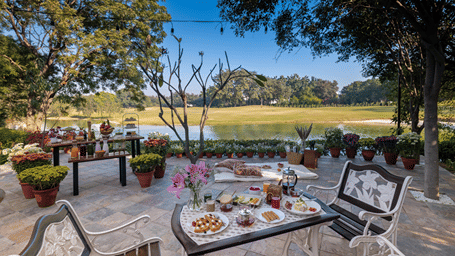 An overview of an outdoor dining area with trees around - Karma Lakelands.