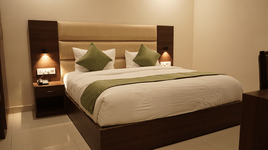 Deluxe room at Five Elements Hotels, Haridwar, featuring a king-sized bed with bedside lamps