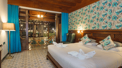 a double bed with side lamps and a curtain covering the swimming pool at Casa Aqua - Symphony Summer Sand Beach Resort And Spa, Neil Island