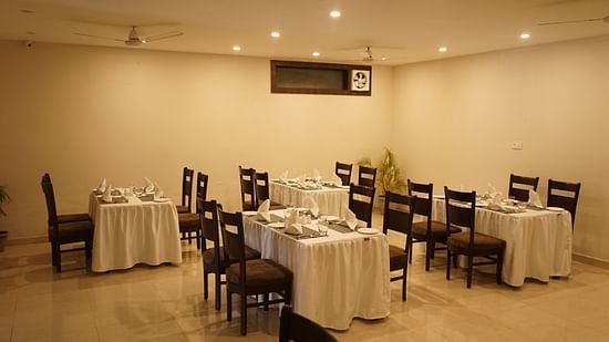 Image of the cafe at Five Elements Hotels, Haridwar, showcasing neatly arranged tables and chairs