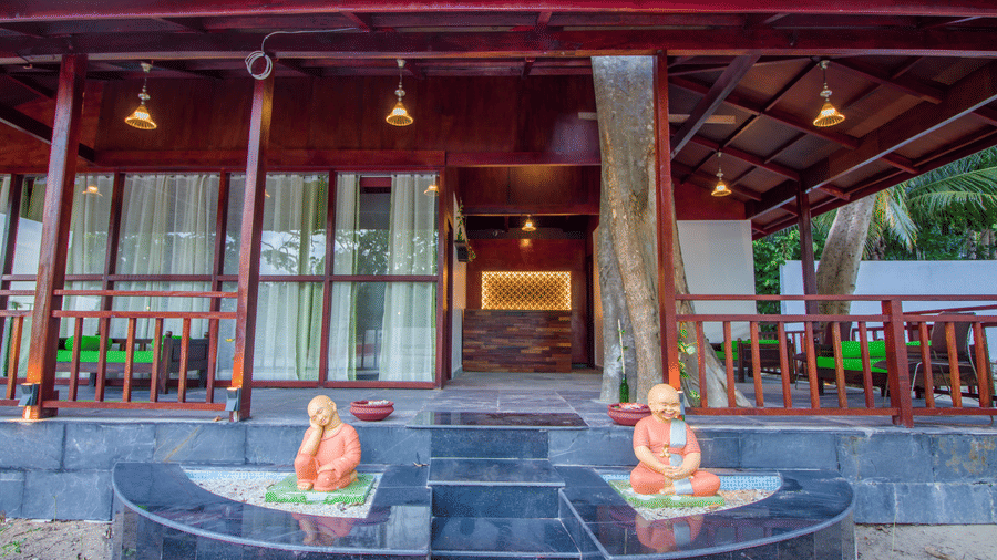 Statues at the entrance of Neil Ocean Spa that has wooden pillars - Symphony Summer Sand Beach Resort And Spa, Neil island