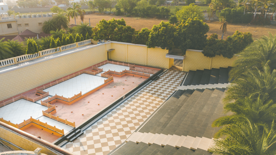 An image of an outdoor amphitheatre surrounded by walls and trees on all four sides - The Garden Ananta Elite, Rajkot