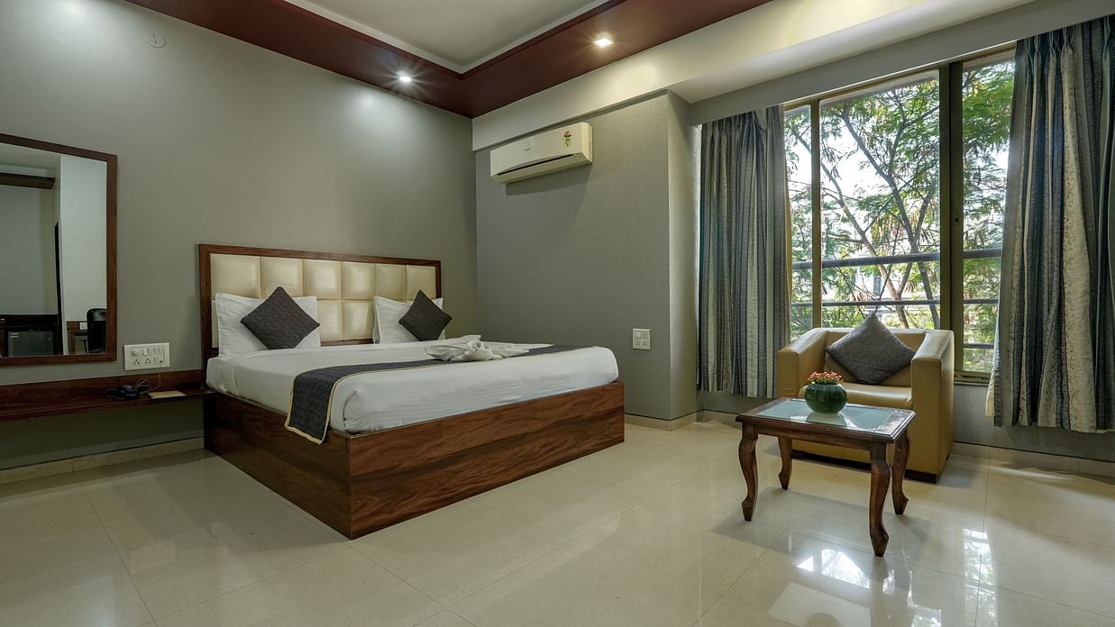 Picture featuring the interior of a room with a large bed, coffee table and a sofa and a large window