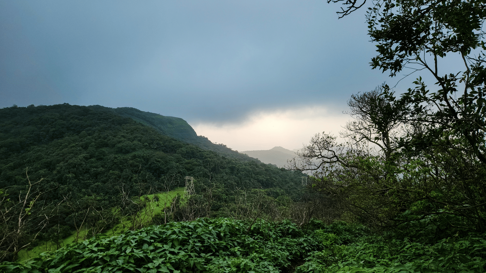 An overview of the beautiful Khandala Hills with forest cover and mountains covered by fog.