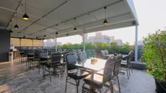 An image of a restaurant at the rooftop where many tables and chairs are placed -  Magnus Fortune House, Magarpatta