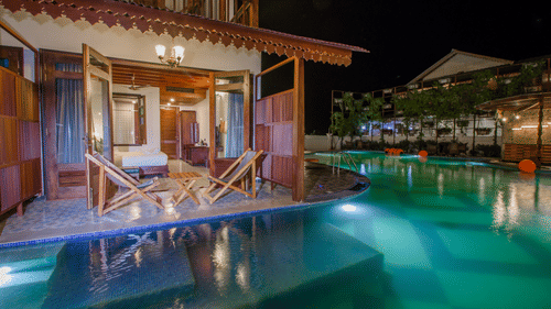 A swimming pool near Casa Aqua Room with chairs on the balcony at Symphony Summer Sand Beach Resort And Spa, the best resort in Neil Island, Andaman.