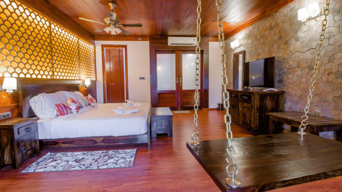 Interior view of our suites in Neil Island with a double bed, a swing and a TV at Symphony Summer Sand Beach Resort And Spa, Neil Island