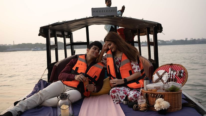 a couple with a picnic basket on a boat that is sailing on the ocean - Polo Floated Kolkata