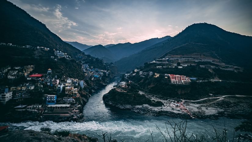 a confluence of two waterbodies with a small valley in view and mountains in the background