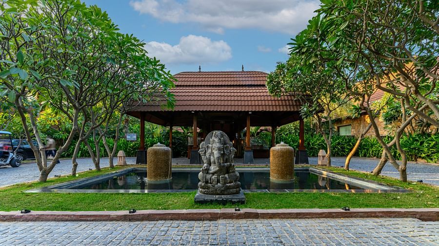 A decorative shade at our 5-star resort in Pushkar with a Ganesh statue, a green patch and trees 