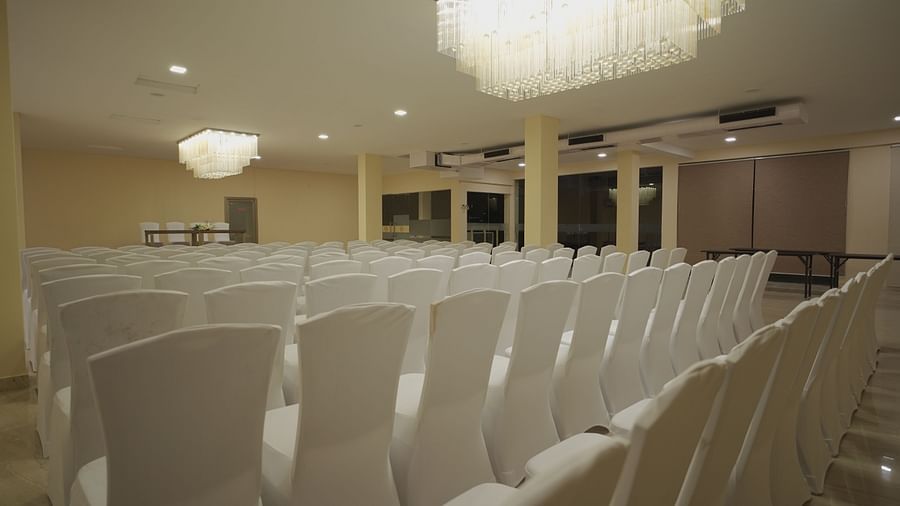 Chairs in clean white covers facing the podium at Citrus Classic Resorts and Spa Mahabalipuram ECR in the spacious Apollo Banquet Hall for a conference