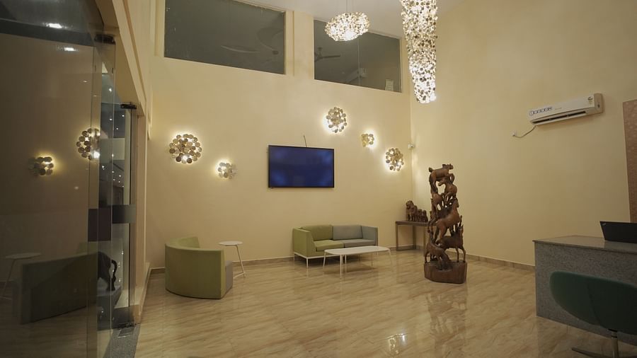 The lobby at Citrus Classic Resorts & Spa Mahabalipuram ECR exudes elegance with its chic seating, floral wall sconces, and an artistic chandelier. The wooden horse sculpture adds a touch of grandeur to the space