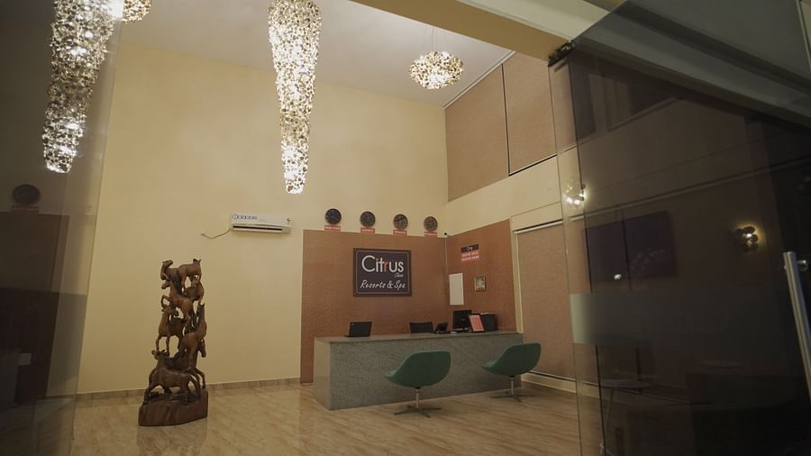 Reception at Citrus Classic Resorts and Spa Mahabalipuram ECR featuring warm lights hanging from the ceiling and large showpiece next to the reception desk