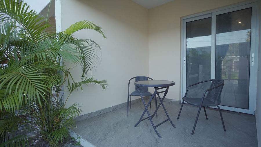 A sitting area at Citrus Classic Resorts and Spa Mahabalipuram ECR outside of the room with a couple of chairs and a coffee table