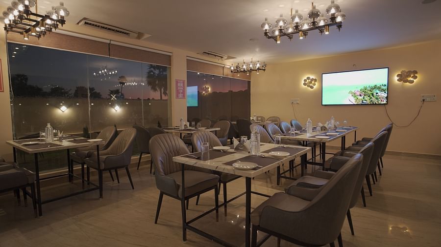 The restaurant at Citrus Classic Resorts & Spa offers elegant seating, stylish lighting, and a scenic view, creating a warm dining atmosphere at Citrus Classic Resorts and Spa Mahabalipuram ECR