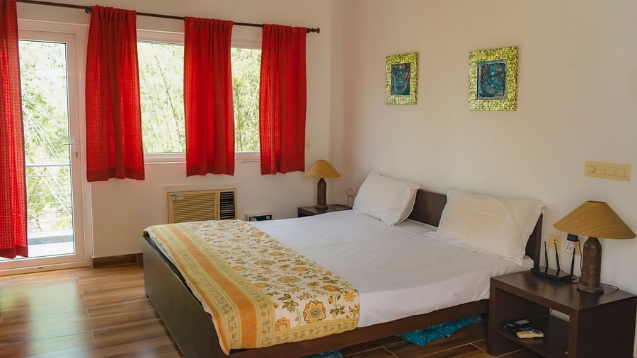 King bed with red curtains on the windows at el benito goa